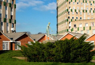 Elizabeth Frink’s ‘The Blind Beggar and His Dog’ in front of the bungalows of Cranbrook Estate.